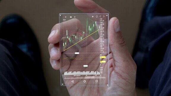 一个男人用智能手机分析股票市场全息图形股票与未来的技术