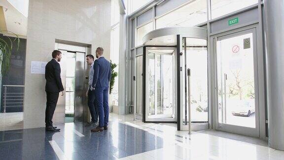 在办公室大堂开会后一群商人走进了电梯
