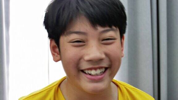 亚洲孩子的肖像看着镜头微笑的脸慢镜头4k可爱的泰国少年前男孩