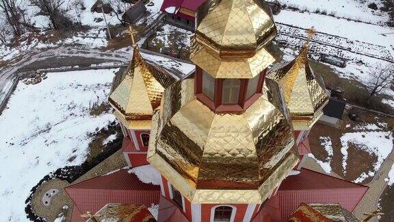 冬季空中俯瞰喀尔巴阡村金色圆顶的乌克兰教堂
