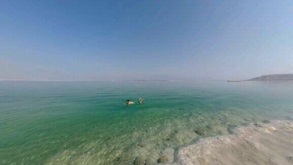 一名男子在以色列死海的纯盐水中游泳