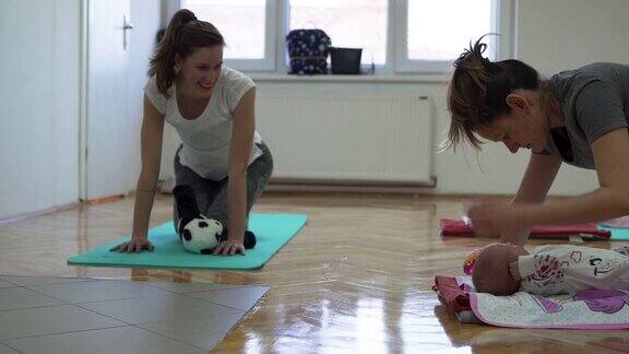 母亲和婴儿在健身班与教练