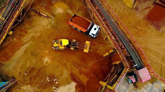 挖掘机装载机在自卸车中装载沙子鸟瞰图砂工作