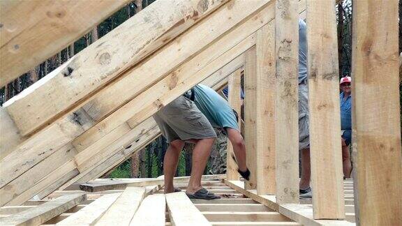 屋顶工人在屋顶上工作建筑工人用锤子锤钉子