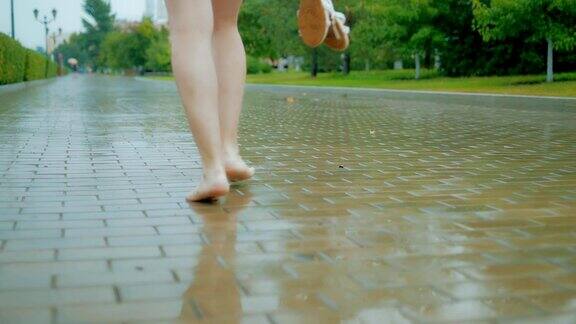 腿的特写女孩赤脚走在公园在恶劣的天气