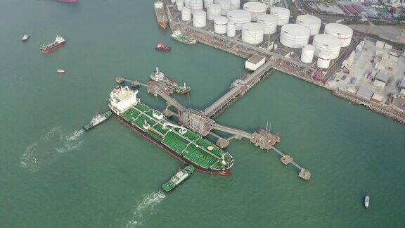 鸟瞰图拖船推油船到装卸码头从储油罐装卸油