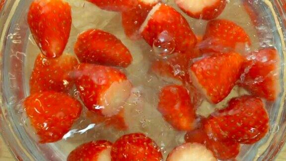 把鲜红的草莓倒进一碗水里慢吞吞的