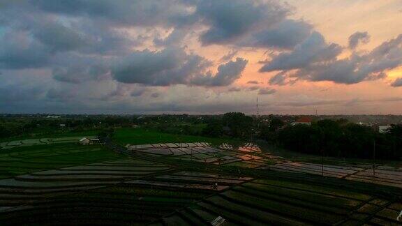 印度尼西亚巴厘岛沧古日落时分稻田和乡村道路的彩色航拍镜头