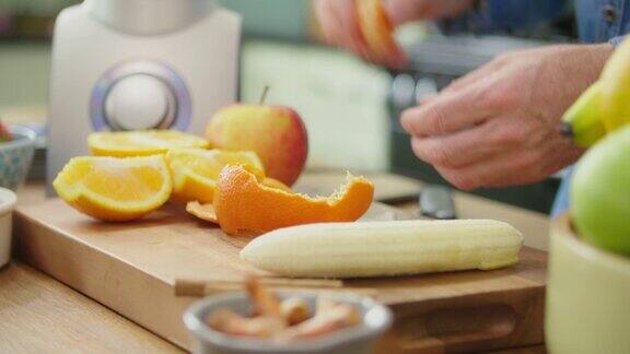 在切菜板上剥橘子和切香蕉的人