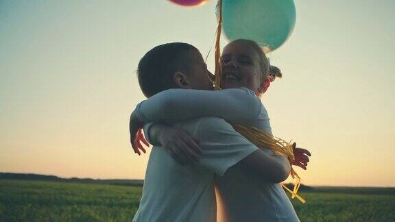 男孩和女孩高高兴兴地爬上夕阳手里拿着气球原始视频记录