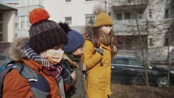 三个孩子戴着防毒面具去上学