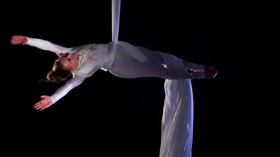 女舞者在空中表演丝绸空中表演柔术空中表演丝带空中表演织物慢动作