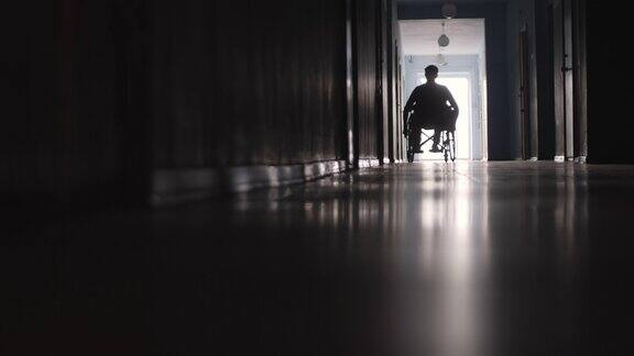 在医院走廊上坐轮椅的截瘫病人剪影