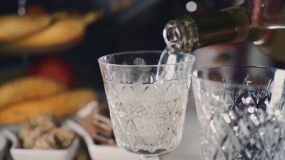 香槟从瓶子里倒进玻璃杯里玻璃上方可见气泡在近距离拍摄
