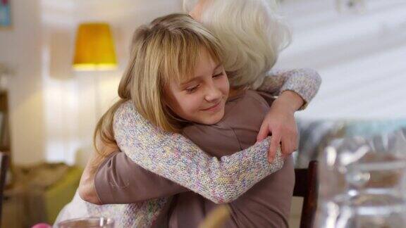 可爱的孙女拥抱祖母微笑着