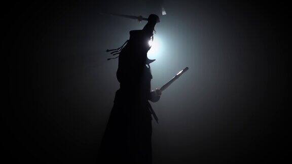 剪影剑道大师正在用武士刀练习武术慢动作