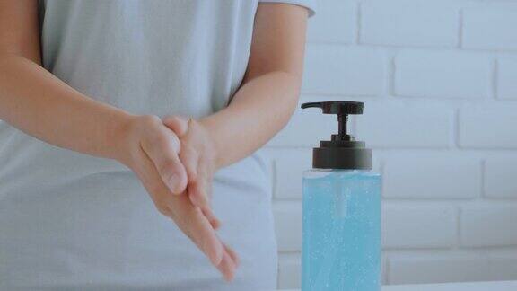 女性手部使用酒精凝胶清洁洗手液防病毒细菌卫生保健理念在家中预防Covid-19病毒