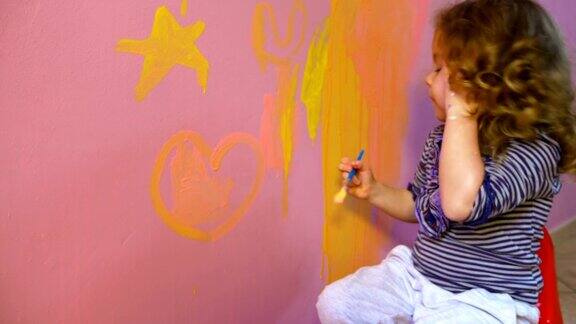 小女孩在墙上画星星和心
