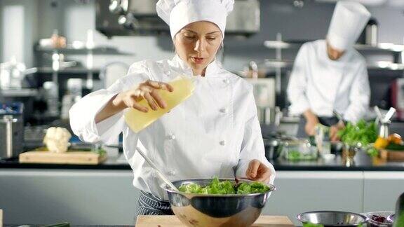在一家著名的餐厅女厨师准备沙拉广告油她在一家现代化的大厨房工作