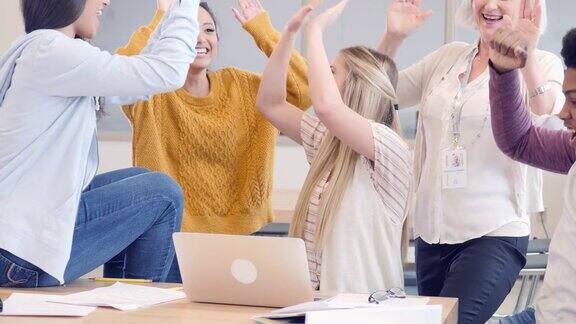 兴奋的高中学生和老师庆祝一个获奖项目