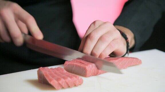厨师用锋利的刀切金枪鱼片做寿司