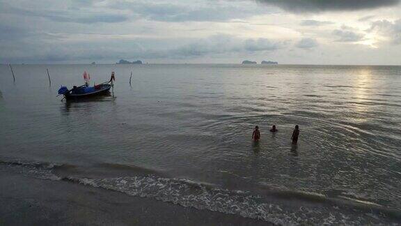 朋友们在空中海滩的海浪中玩耍