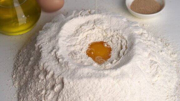 面包师在做面团时把鸡蛋打碎成面粉面团准备过程鸡蛋倒入面团