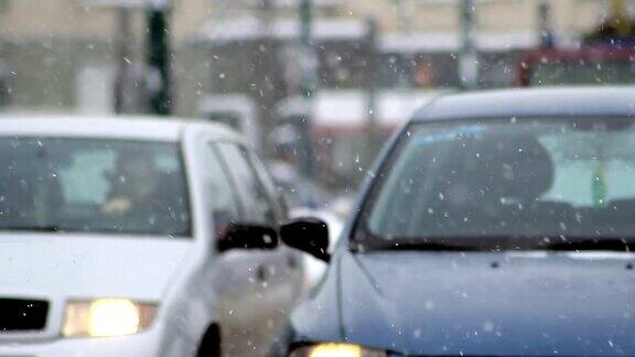 车流在雪中雪花飘飘汽车在湿滑的路上行驶