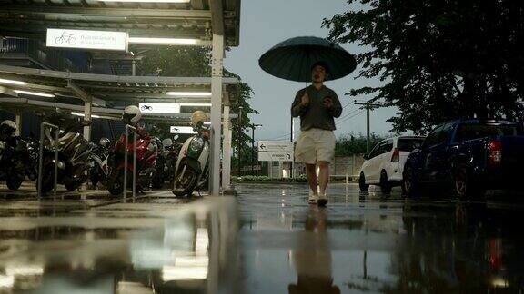 亚洲男人在雨中打着伞感觉很好