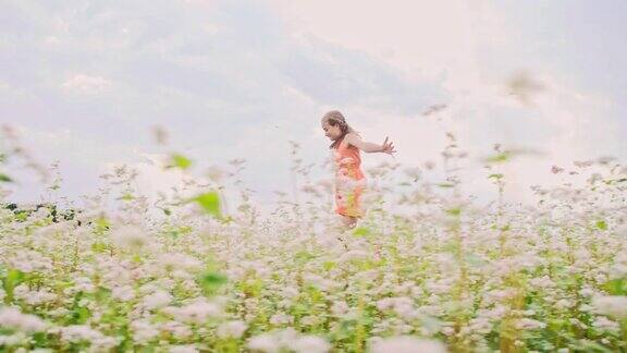 SLOMO快乐的女孩跳跃和旋转在田野