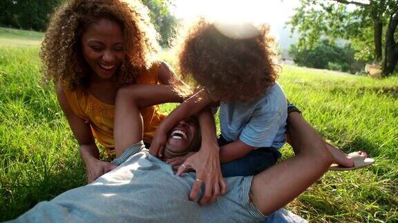 令人惊叹的非洲裔美国家庭在愉快地笑着的同时彼此放松