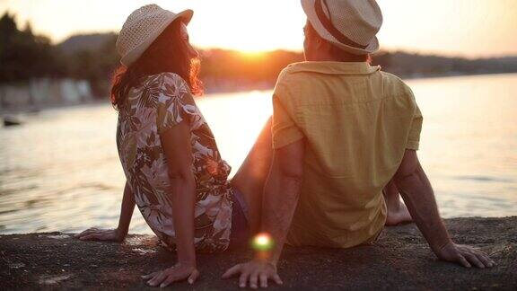 一对浪漫的年轻夫妇在海边看日落