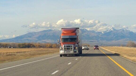 特写:半卡车沿着高速公路行驶经过农田和牧场