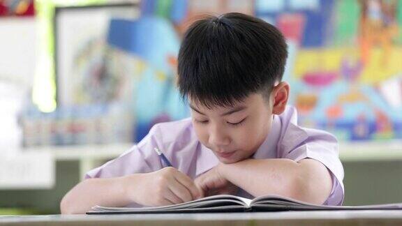 亚裔孩子穿着学生校服做读书写字的学校作业