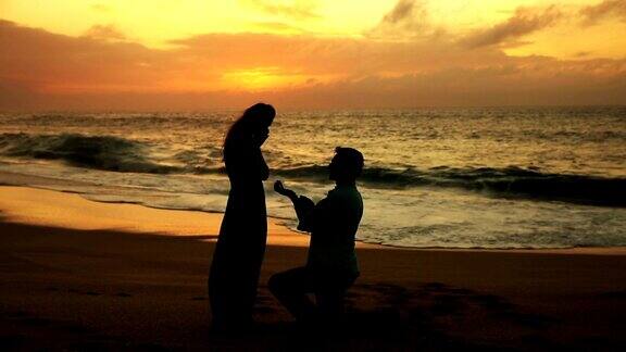 男人向女人求婚夕阳照耀的海滩