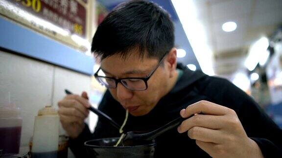 亚洲男子在吃香港馄饨虾面汤