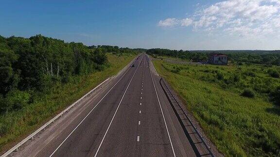 鸟瞰图上的汽车行驶在空旷的乡村道路在阳光明媚的日子