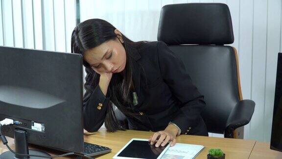 年轻美丽疲惫的亚洲女商业女会计职员在现代办公室的椅子上打盹辛苦工作后疲惫的女商人疲惫的上班族在工作场所睡觉