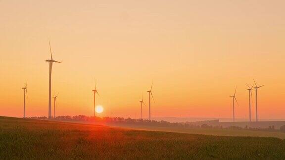 日出时风力涡轮机在乡间旋转