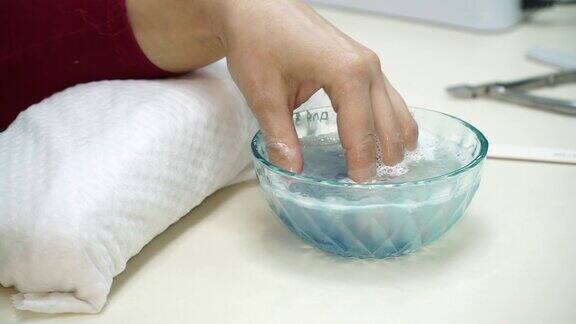 修指甲美容院美甲师负责护理指甲的程序保湿指甲的过程中手放在浴缸里用水特写镜头