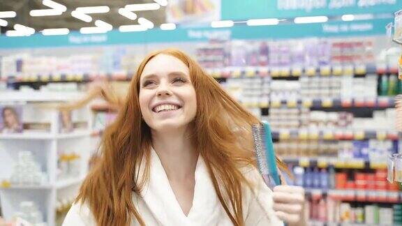 快乐的红发女性在店里挑选新梳子