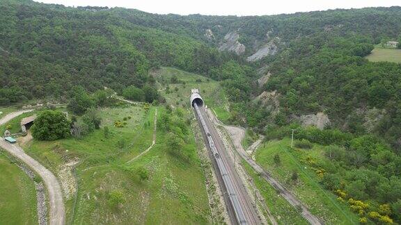 一列高速客运列车离开山脚下隧道的无人机全景图俯瞰法国南部的群山