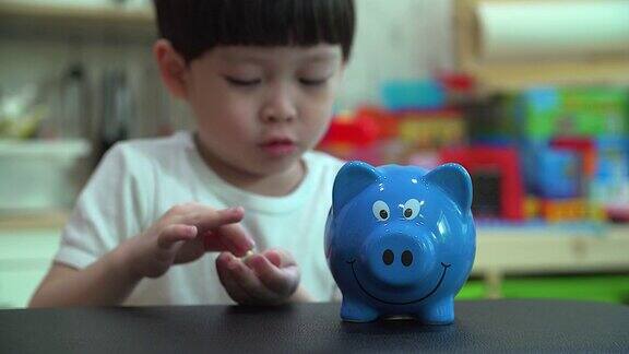 小男孩把一枚硬币放进扑满孩子为未来存钱