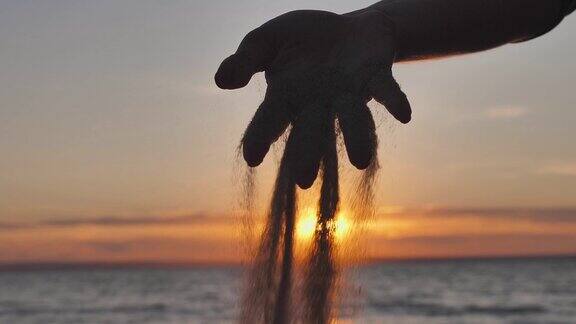 日落时沙子从女人的手指间滑落时间和生命的短暂