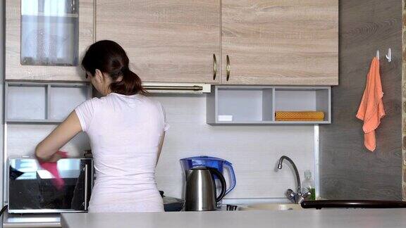年轻的家庭主妇在厨房打扫公寓