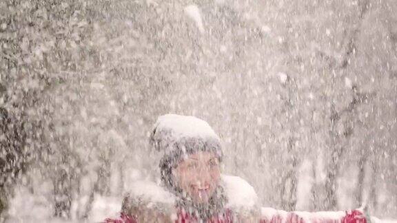 快乐的女孩在公园的大雪下纺纱