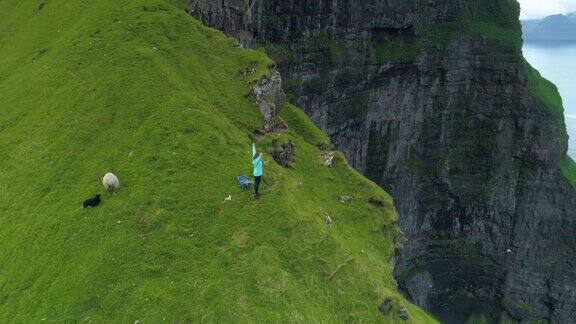 天线:一个快乐的女人伸开双臂站在悬崖边上