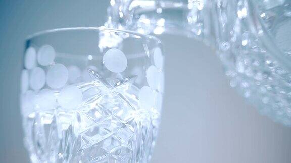 伏特加从玻璃瓶倒入白色背景的玻璃杯中