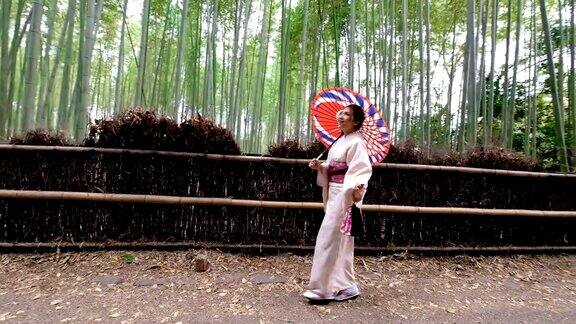 4K吊车拍摄:日本京都岚山和佐野的竹林里一名身穿传统和服的亚洲女性在行走欢迎你来到日本