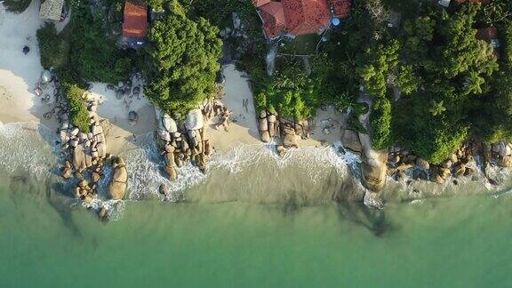 无人机空中鸟瞰海滩与绿松石色的水日落